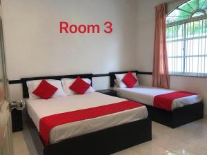 two beds in a room with a room three sign at 66 Semi-D Homestay in Teluk Intan