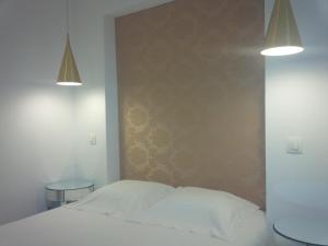 um quarto com uma cama branca e duas luzes em Costa Castle Apartment em Lisboa