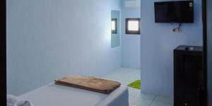 a white bathroom with a tub with a towel on it at Citra Green House Syariah near Universitas Tulungagung in Tulungagung