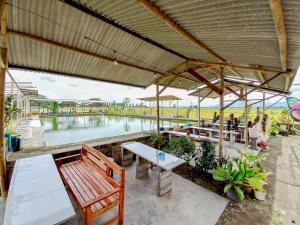a patio with a table and benches and a pool at Citra Green House Syariah near Universitas Tulungagung in Tulungagung