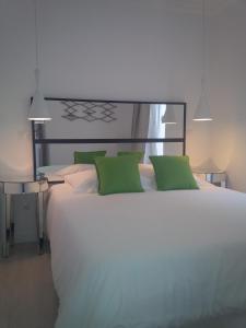 リスボンにあるCosta Castle Apartmentのベッドルーム(緑の枕が付く大きな白いベッド付)