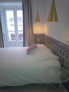 een slaapkamer met een wit bed en een raam bij Costa Castle Apartment in Lissabon