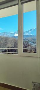 una ventana con vistas a las montañas cubiertas de nieve en Los argentos en Ushuaia