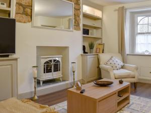 a living room with a tv and a fireplace at Plum Cottage in Castle Cary