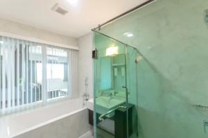 a bathroom with a glass shower and a sink at Eastpana Hotel - SHA Extra Plus in Si Racha
