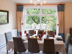 a dining room with a table and a large window at Woodland View in Whitewell