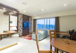 a living room with a table and a dining room at Hotel Santika Premiere Ambon in Ambon