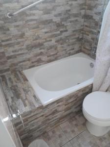 a bathroom with a tub and a toilet and a shower at Cabanas bahia inglesa in Bahia Inglesa