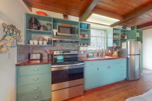 a kitchen with green cabinets and a stainless steel refrigerator at Bay Bliss #2 in Reedsport