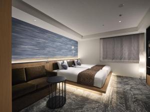 pokój hotelowy z łóżkiem i kanapą w obiekcie Villa Fontaine Grand Osaka Umeda w Osace