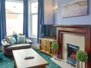 a living room with a fireplace and a tv at Sea The Stars in Hornsea