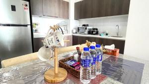 una cocina con una mesa con botellas de agua. en GOLDEN TROIKA KOTA BHARU - 2 bedrooms, en Kota Bharu