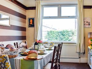 a dining room with a table with food and a window at Chaseley House in Blackpool