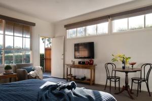 ein Schlafzimmer mit einem Bett und einem TV an der Wand in der Unterkunft Daylesford House Studio in Daylesford