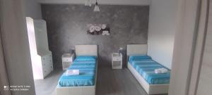 duas camas num quarto com lençóis azuis em Al Corso em Montella