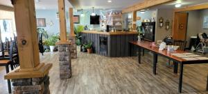 restauracja z barem z drewnianymi podłogami i stołami w obiekcie North Shore Wayside Inn w mieście Blind River