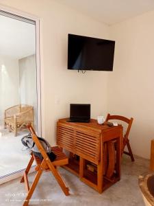 a living room with a television on a wall at Villa Kuxtah, Beautiful bungalow with Private Pool in Tulum