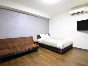 a bedroom with a bed and a couch at Regariain - Vacation STAY 85013 in Okayama