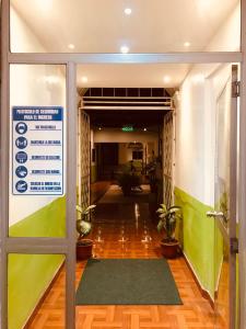 einen Eingang zu einem Bürogebäude mit einem Schild an der Tür in der Unterkunft Quinta San Carlos Hostel in Ibarra