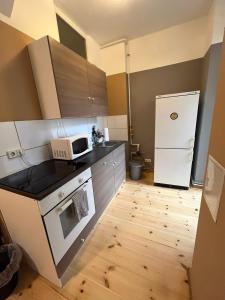 a small kitchen with a microwave and a refrigerator at Pension Thomas Rooms in Berlin