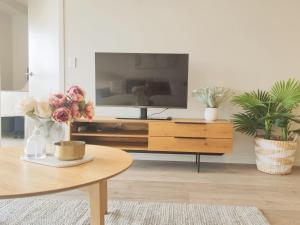 uma sala de estar com uma televisão e uma mesa de centro em Luxurious 2 bedroom apartment Free secure parking em Auckland