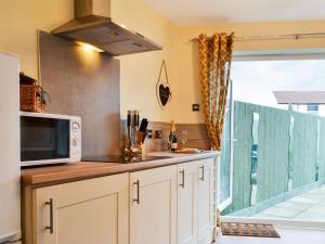 a kitchen with white cabinets and a microwave at The Horseshoes in Hornsea