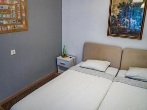 1 dormitorio pequeño con 2 camas y una foto en la pared en Apartment Dubovac, en Karlovac
