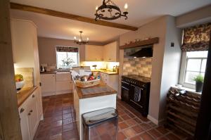 una cucina con armadietti bianchi e stufa nera di Stunning Yew Tree Cottage a Westow