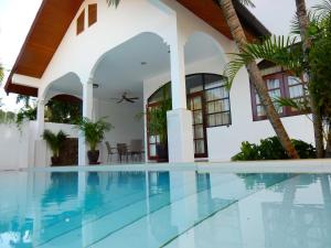 a swimming pool in front of a house at Villa Happy home in Rawai Beach