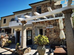 un edificio con una sombrilla delante de él en Bed & Breakfast Mare Isole, en La Maddalena