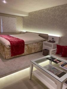 a bedroom with a bed and a coffee table at Hotel Regent (Adult Only) in Nagoya