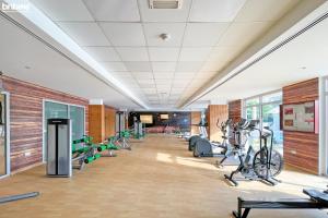 a gym with treadmills and bikes in a room at bnbmehomes - 2 BR Stunning Lake Views in Al Turia - 205 in Dubai