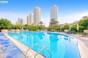 una gran piscina con edificios altos en el fondo en bnbmehomes - 2 BR Stunning Lake Views in Al Turia - 205 en Dubái