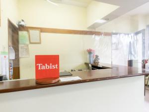 uma mesa com um livro vermelho sentado num balcão em Tabist My Room Tagajjo em Tagajo