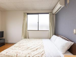 Postel nebo postele na pokoji v ubytování Tabist My Room Tagajjo