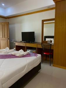 a bedroom with a bed and a desk with a mirror at Parada Place in Khon Kaen