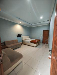 uma sala de estar com uma cama e um sofá em Pondok Dewi em Pangandaran