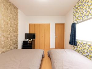 Postel nebo postele na pokoji v ubytování Tabist My Room Tagajjo