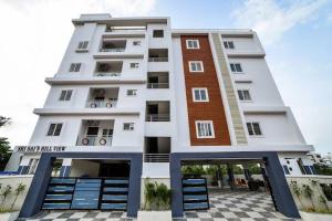 a tall white building with blue steps and a building at HOTEL SRIRAMA INN in Gachibowli