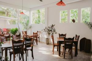 a dining room with tables and chairs and windows at Jungle Soul in Mirissa