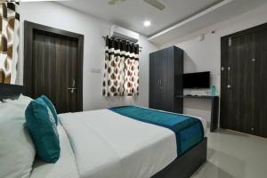 a bedroom with a large white bed with blue pillows at HOTEL SRIRAMA INN in Gachibowli