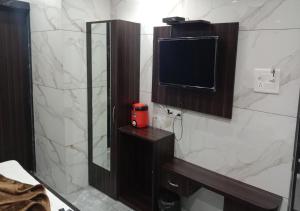 a bathroom with a mirror and a tv on the wall at Hotel Green Park in Ajmer