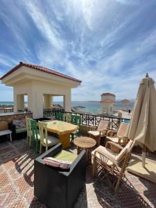 a patio with chairs and tables and an umbrella at Apartman Andalusie in Hurghada