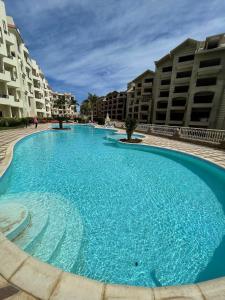 a large blue swimming pool in front of some buildings at Apartman Andalusie in Hurghada