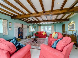 a living room with two red chairs and a fireplace at The Marle in Hazelwood