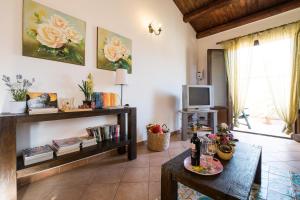 ein Wohnzimmer mit einem Tisch und einem TV in der Unterkunft La Terrazza di Massimo in Palermo