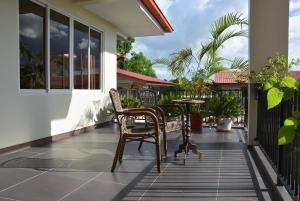 a patio with chairs and a table on a house at Mathurin Appartementen in Paramaribo