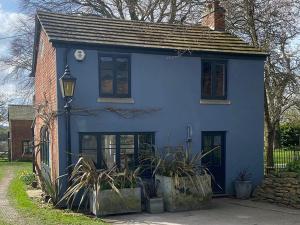 una casa azul con plantas delante en Southfield Art Studio, en Braunston