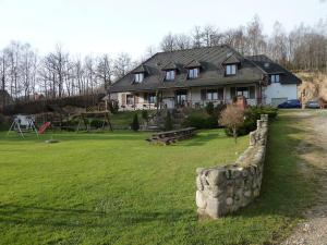 dom z kamienną ścianą przed dziedzińcem w obiekcie Zajazd Pod Skarpą w mieście Mysłakowice
