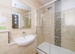 a bathroom with a sink and a glass shower at Larkshayes Cottages in Hawley Bottom